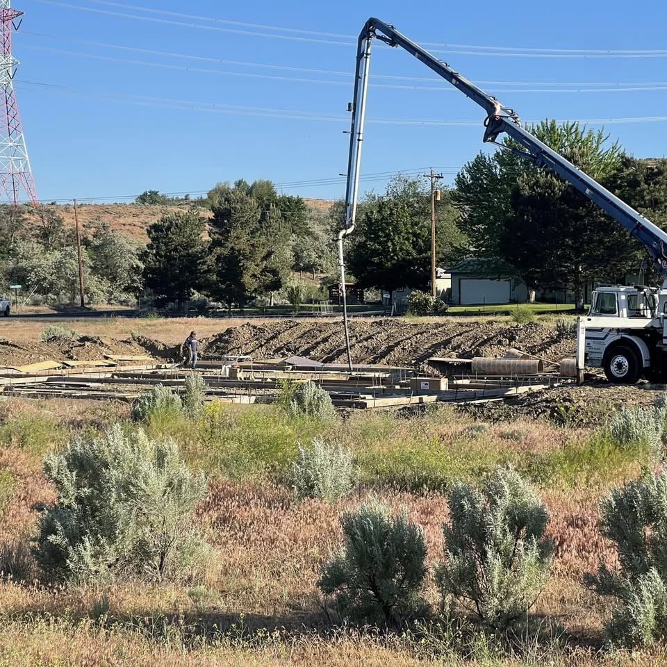 A concrete pump truck pouring a large foundation on a jobsite