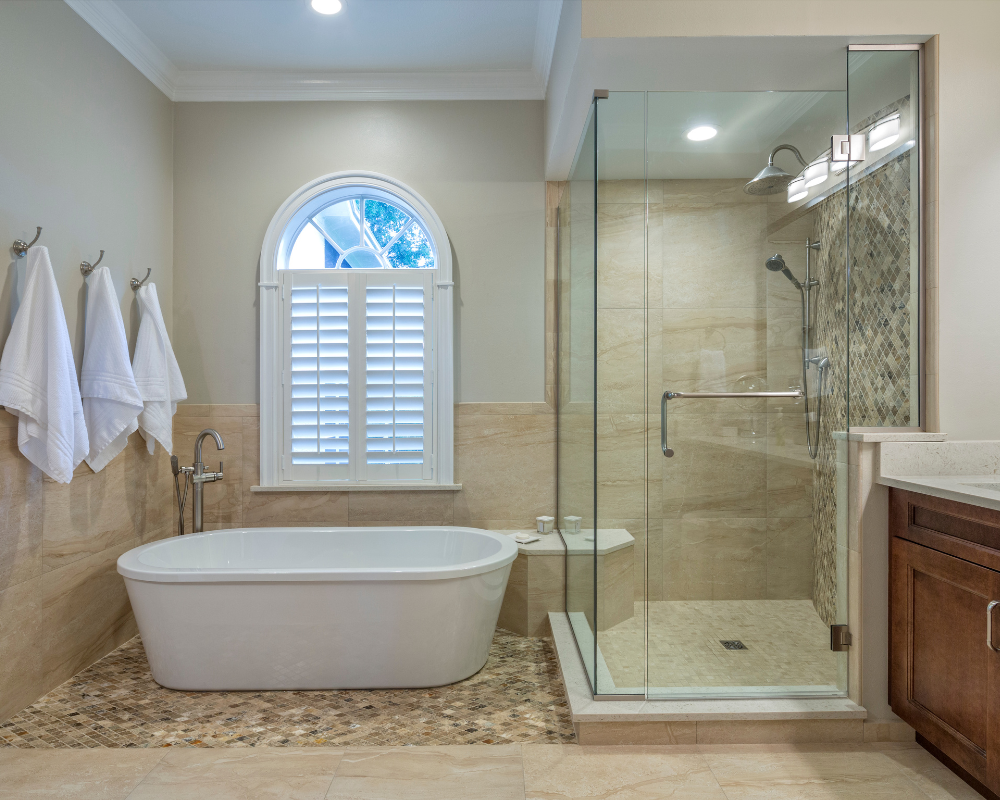 A finished bathroom remodel with a freestanding tub and glass-tile shower