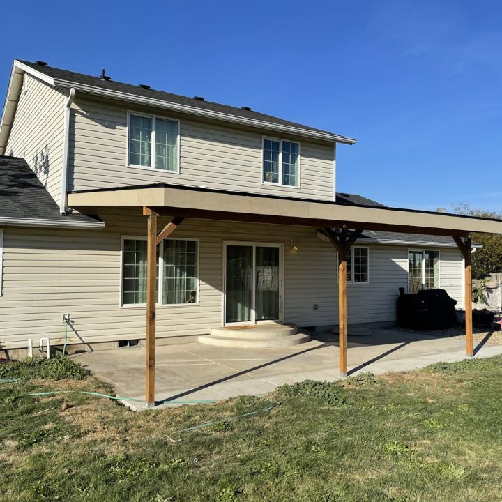 A covered patio built over poured concrete with new siding