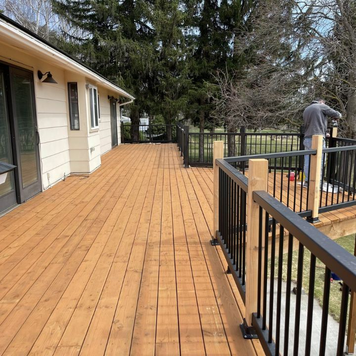 A finished cedar deck with black railing, built by the All Stiles crew
